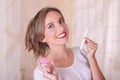 Close up of young beautiful smiling woman holding a menstruation cotton tampon in one hand and with her other hand a Royalty Free Stock Photo