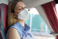 Close up of young beautiful woman with medical mask FFP2 KN95 sleeping sitting in the bus. Bus passenger traveling safely sitting