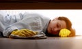 Close up of young beautiful woman with yellow rubber gloves and rag is cleaning floor under bed at home. Concept of Royalty Free Stock Photo