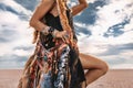 Close up of young boho style woman holding big stylish bag on the beach at sunset Royalty Free Stock Photo