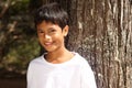 Close up young boy big smile leaning against tree Royalty Free Stock Photo