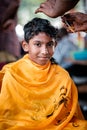 Close-up of young boy devotee getting tonsured or head shaving ritual in Thaipusam Festival