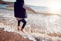 Close Up Of Young Boy Having Fun Jumping Over Waves On Beach