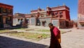 CLOSE UP: Young buddhist monk walks across the large yard in Sakya monastery.