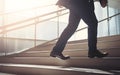 Close up young businessman feet sprinting up stairs