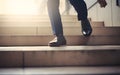 Close up young businessman feet sprinting up stairs