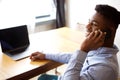 Close up young businessman talking on phone while sitting at desk with laptop computer Royalty Free Stock Photo