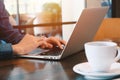 Young businessman working remotely with computer laptop and coffee at home office during the spread of pandemic Covid-