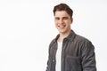 Close up of young candid guy, handsome man smiling white teeth, standing relaxed and casual against isolated studio