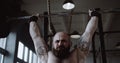 Close-up young Caucasian athlete man lifting heavy barbell in large hardcore gym hall. Ambition and challenge concept. Royalty Free Stock Photo