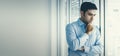 Close-up young Caucasian businessman standing depressed near a window in the office. Stressed and worried about the economic Royalty Free Stock Photo