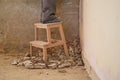 Unrecognizable young builder legs on a small wood ladder on a debris.