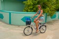 CLOSE UP: Young Caucasian female tourist rides a bike as she goes snorkeling. Royalty Free Stock Photo
