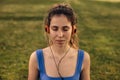 Close-up of young caucasian girl in headphones relaxes closing her eyes outdoors.