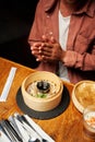 Close-up of young caucasian man in casual clothing with dumplings in steamer at restaurant