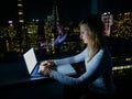CLOSE UP: Young Caucasian woman doing research on her laptop late at night. Royalty Free Stock Photo