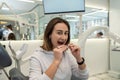 young Caucasian woman holding an invisible aligner that she wants to put on her teeth. Royalty Free Stock Photo