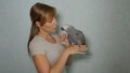 CLOSE UP: Young woman lets her grey parrot sit on her finger while feeding it. Royalty Free Stock Photo