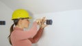 CLOSE UP: Woman screws screws into wall while installing electrical sockets Royalty Free Stock Photo