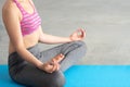 Close up of Young Caucasian woman in yoga sport clothes meditating and doing lotus yoga position in peaceful and calm posture.