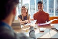 Close-up of young colleagues in a commission having a pleasant talk with a young male applicant during an interview for a job.