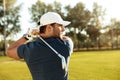 Close up of a young concentrated man shooting golf ball Royalty Free Stock Photo