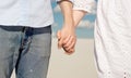 Close-up of a young couple enjoying the sunset in the dunes holding hands. Romantic traveler walks through the desert Royalty Free Stock Photo