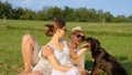 CLOSE UP: Young couple pets their lovely border collie puppy in sunny meadow. Royalty Free Stock Photo