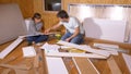 CLOSE UP: Young couple sits on the floor and assembles a bed in their new home.