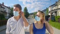 CLOSE UP Young couple takes off their protective facemasks after end of covid-19
