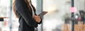 Close up young entrepreneur woman using her digital tablet while standing in office with copy space Royalty Free Stock Photo