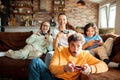 Young family playing video games together in the living room on a gaming console Royalty Free Stock Photo