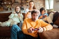 Young family playing video games together in the living room on a gaming console Royalty Free Stock Photo