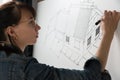 Close-up of a young female architect drawing a sketch for a new famaly home project. Concept of work on technical drawings Royalty Free Stock Photo