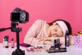 Close up young female blogger, looks tired, falls asleep while recording new video on camera, advertising new beauty products,