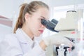 Close up young female cacausian Scientist researcher using microscope Royalty Free Stock Photo
