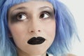 Close-up of young female punk with black lipstick, eye make-up and blue hair