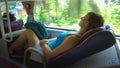 CLOSE UP: Young female traveler sleeping tight while driving in a sleeper bus.
