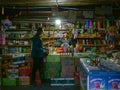 CLOSE UP: Young female traveler talks to a local Tibetan man selling groceries.