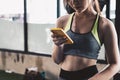 close up young fit woman using smart phone at gym Royalty Free Stock Photo