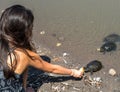 Close up of young girl feeding turtles at the beach