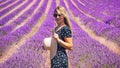 Close up of a young girl in a floral dress with a hat on her head between lavender in southern Provence Valensole France Royalty Free Stock Photo