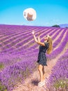 Close up of a young girl in a floral dress with a hat on her head between lavender in southern Provence Valensole France Royalty Free Stock Photo