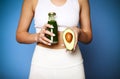 Close up of young girl holding avocado and green smoothie