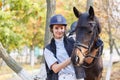 Close-up of a young girl hugged the horse`s face with her hands.