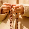 Close up young girl praying and holding a wooden rosary Royalty Free Stock Photo