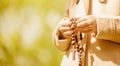 Close up young girl praying with wooden rosary. Free copy space for design Royalty Free Stock Photo