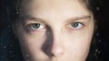 Close-up of a young girl`s eye behind a glass of a window with raindrops. Quarantine mood, home isolation, hope, loneliness, Royalty Free Stock Photo