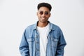 Close up of young good-looking cheerful fashionable dark-skinned man with afro hairstyle in white shirt under denim