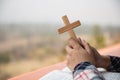 Close up young hands holding wooden cross over holy bible and praying. christian concept Royalty Free Stock Photo